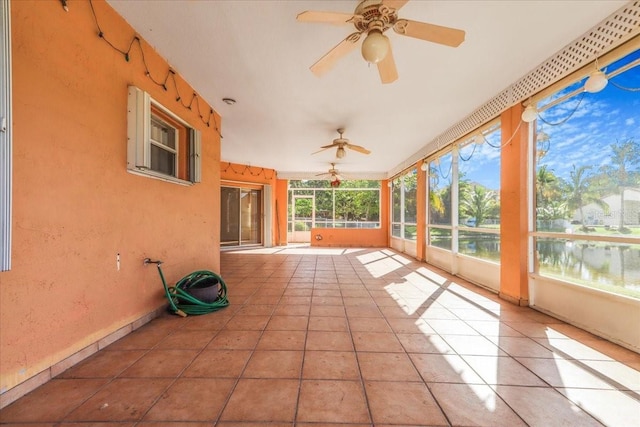 unfurnished sunroom featuring a water view and ceiling fan