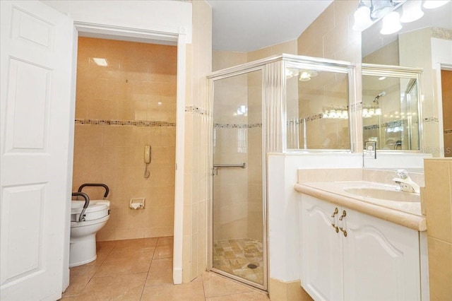 bathroom featuring an enclosed shower, vanity, tile patterned flooring, and tile walls