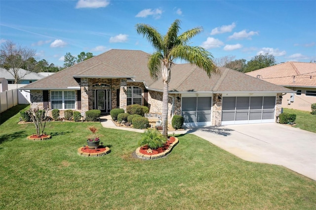 view of front of property featuring roof with shingles, fence, a garage, driveway, and a front lawn