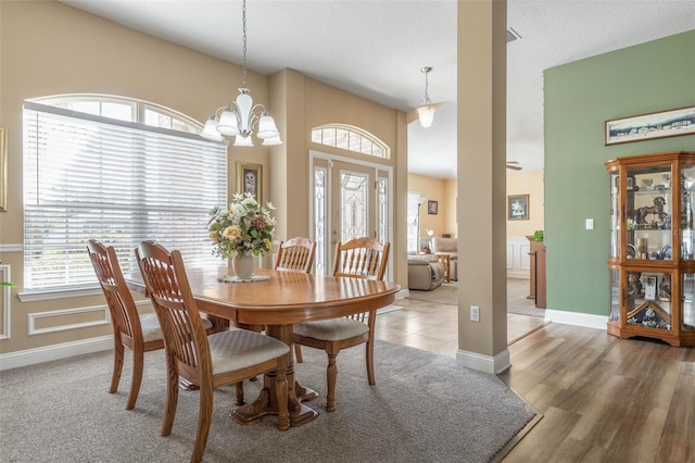 dining space featuring a notable chandelier, baseboards, a wealth of natural light, and wood finished floors