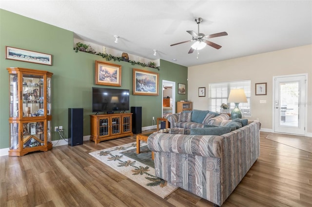 living room with wood finished floors, a ceiling fan, and baseboards