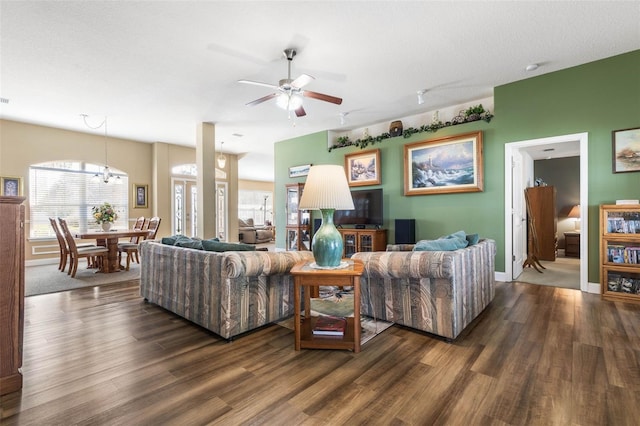 living area featuring a healthy amount of sunlight, dark wood-style floors, baseboards, and a ceiling fan