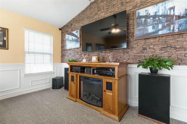 bar with a ceiling fan, light colored carpet, lofted ceiling, wainscoting, and a textured ceiling