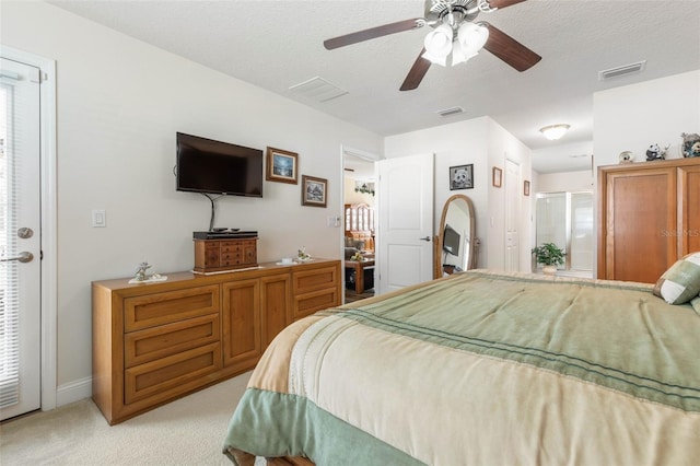 bedroom featuring a textured ceiling, visible vents, and light colored carpet