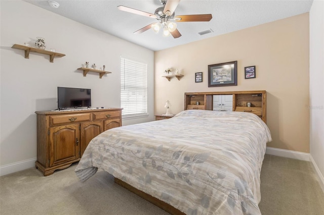 bedroom featuring baseboards, a ceiling fan, visible vents, and light colored carpet