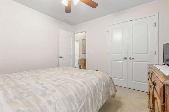 bedroom featuring a closet, light carpet, ceiling fan, and visible vents