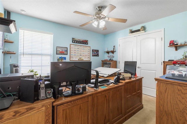 office with a textured ceiling, a ceiling fan, and light colored carpet