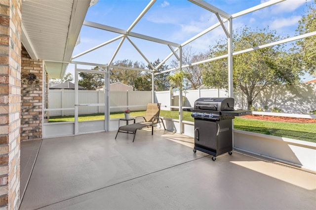 view of patio / terrace featuring glass enclosure, a fenced backyard, and area for grilling