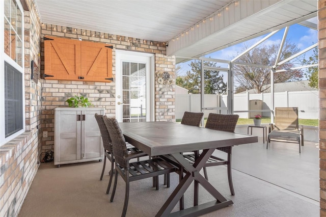 view of patio / terrace with outdoor dining area, glass enclosure, and a fenced backyard