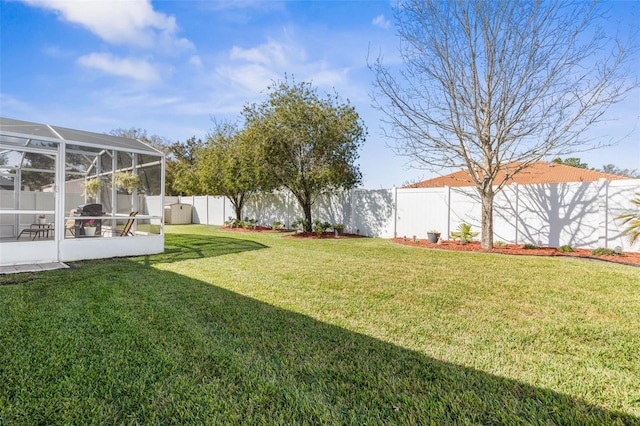 view of yard with glass enclosure and a fenced backyard