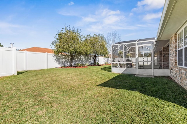 view of yard featuring glass enclosure and a fenced backyard