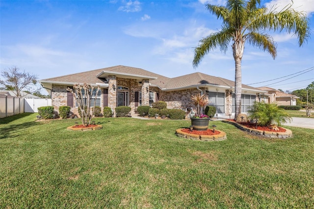 view of front of property with brick siding, fence, and a front yard