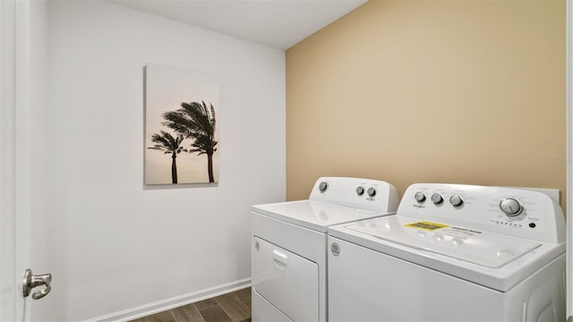 washroom with dark hardwood / wood-style floors and washing machine and dryer