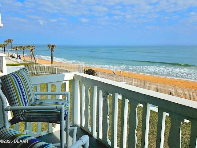 balcony with a water view and a beach view