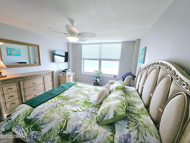 bedroom with ceiling fan and a textured ceiling