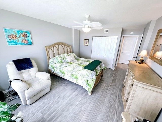 bedroom featuring a textured ceiling, wood-type flooring, a closet, and ceiling fan