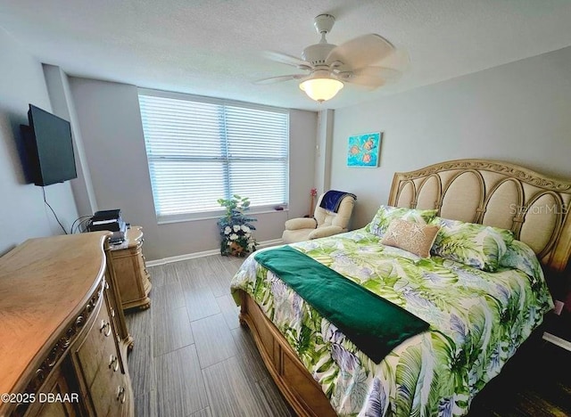 bedroom featuring hardwood / wood-style flooring, ceiling fan, and a textured ceiling