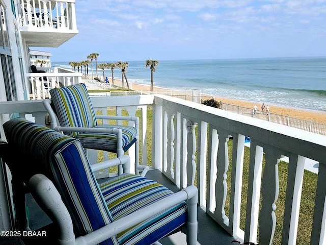 balcony with a water view and a beach view