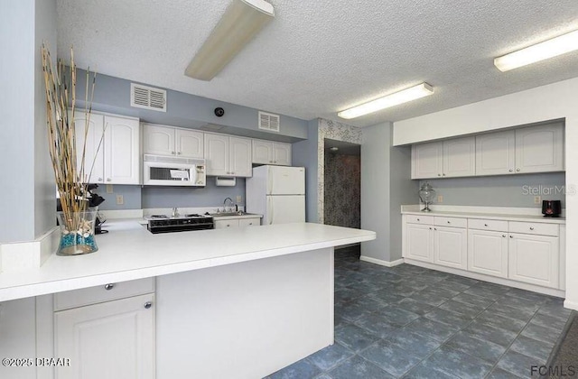 kitchen with white cabinetry, sink, white appliances, kitchen peninsula, and a textured ceiling