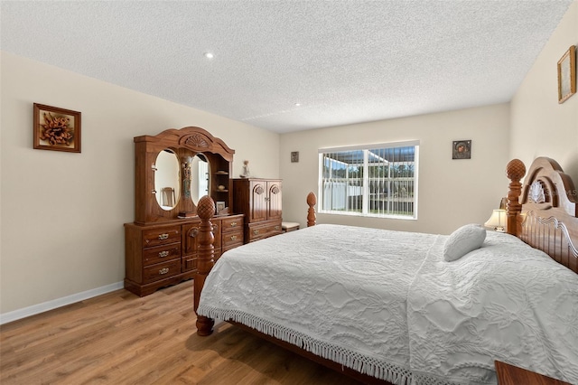 bedroom featuring wood-type flooring and a textured ceiling