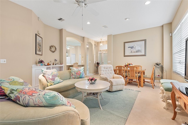 carpeted living room with ceiling fan