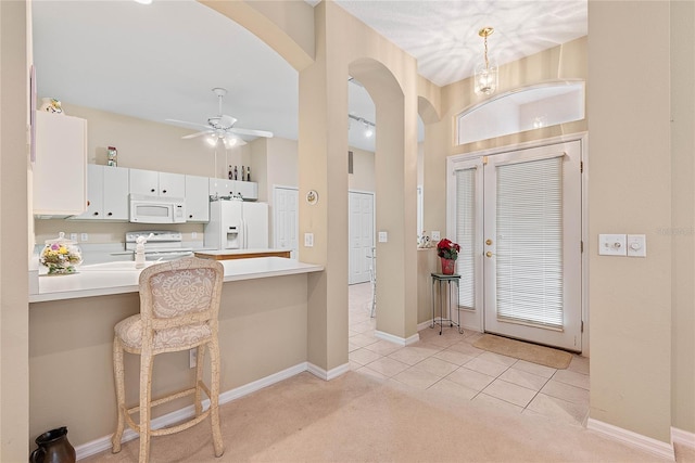 interior space featuring sink, light colored carpet, ceiling fan, and a towering ceiling