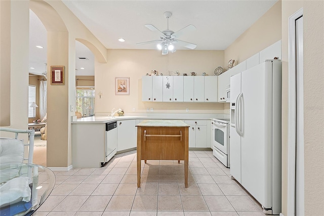 kitchen featuring white appliances, ceiling fan, white cabinetry, a kitchen island, and light tile patterned flooring