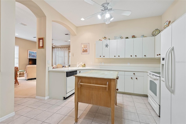 kitchen with white cabinets, a center island, light tile patterned floors, ceiling fan, and white appliances