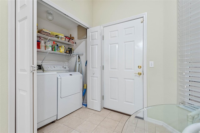 clothes washing area with light tile patterned floors and washer and clothes dryer