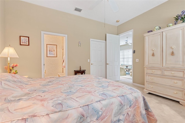 bedroom with connected bathroom, light carpet, and ceiling fan