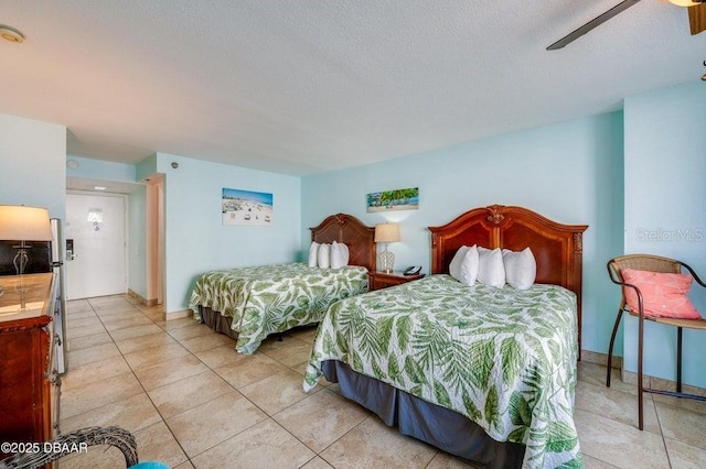 bedroom featuring light tile patterned floors, a textured ceiling, and ceiling fan