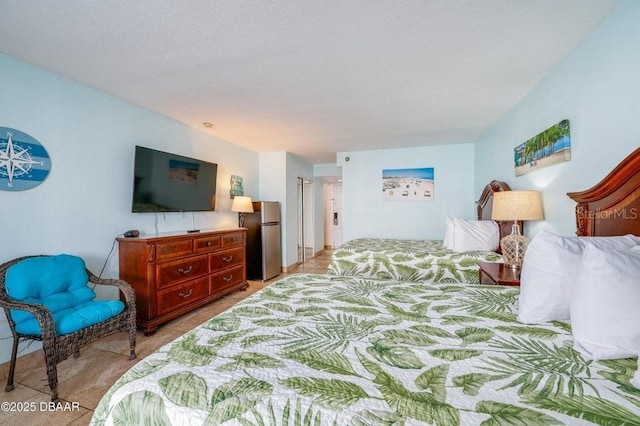 bedroom featuring stainless steel fridge and a textured ceiling