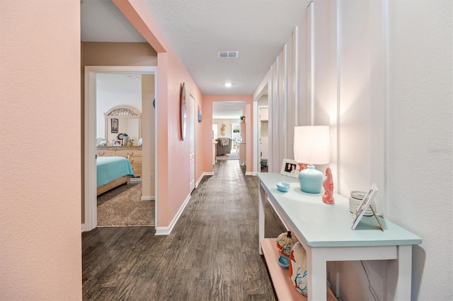 corridor with dark hardwood / wood-style flooring