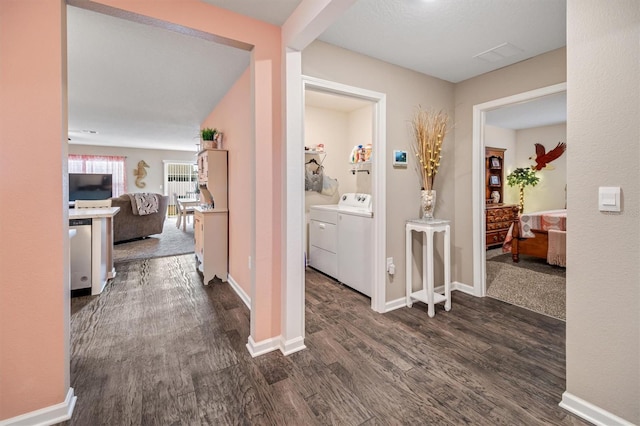 hallway with dark hardwood / wood-style flooring and washer and dryer