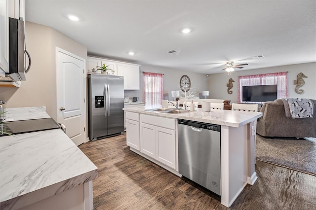 kitchen featuring stainless steel appliances, sink, a center island with sink, and white cabinets