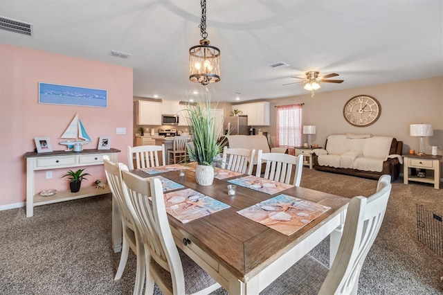 dining area with ceiling fan with notable chandelier and dark carpet