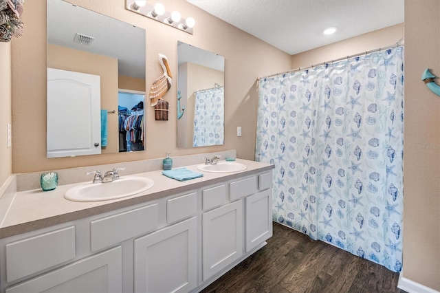 bathroom with hardwood / wood-style flooring, vanity, and curtained shower