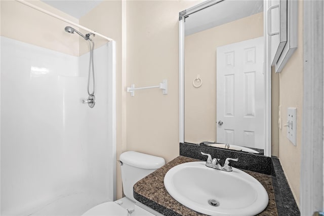 bathroom with walk in shower, vanity, and toilet