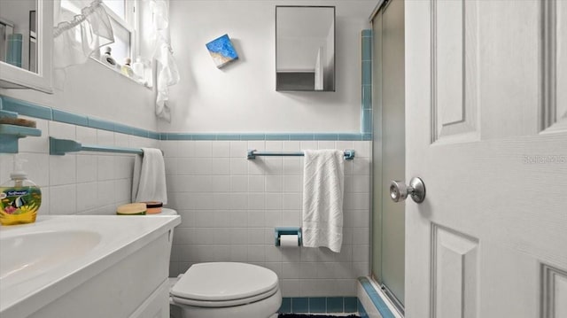 bathroom featuring vanity, tile walls, an enclosed shower, and toilet