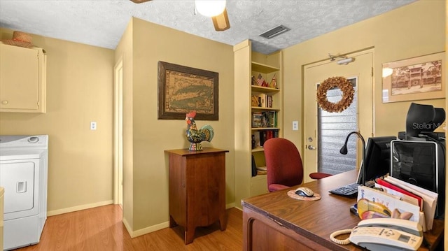 office area featuring ceiling fan, washer / clothes dryer, a textured ceiling, and light wood-type flooring