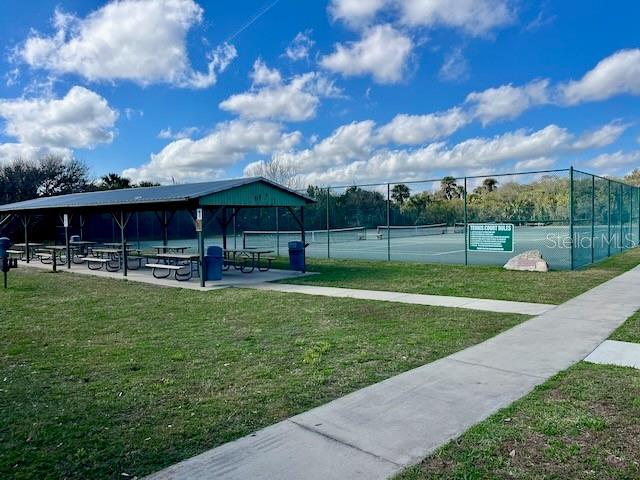 view of community featuring a yard and tennis court