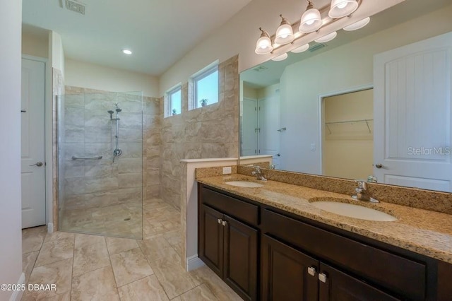 bathroom with vanity and tiled shower