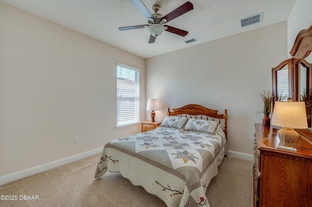 bedroom with light colored carpet, a textured ceiling, and ceiling fan