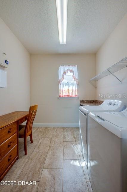 laundry area featuring a textured ceiling and washing machine and clothes dryer