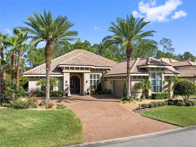 mediterranean / spanish-style house featuring a garage and a front lawn