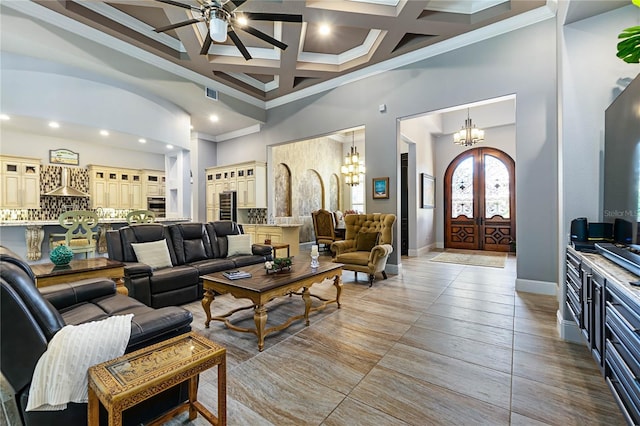 living room featuring a high ceiling, coffered ceiling, ornamental molding, french doors, and beamed ceiling