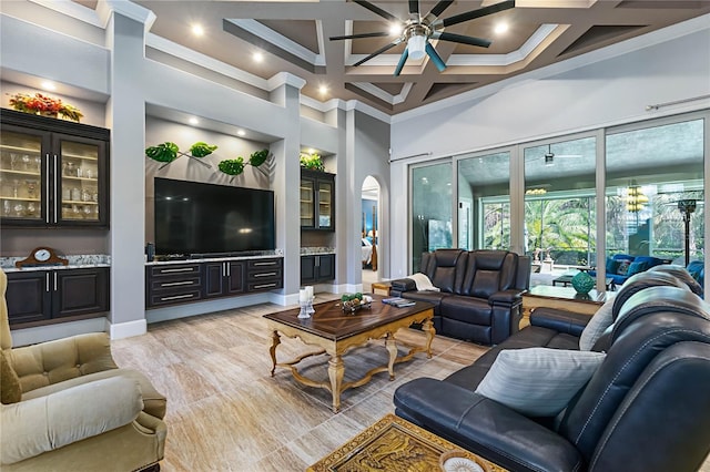 living room with coffered ceiling, crown molding, a towering ceiling, ceiling fan, and beam ceiling