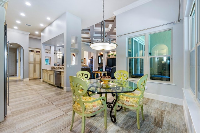 dining area featuring coffered ceiling, sink, a chandelier, ornamental molding, and beam ceiling