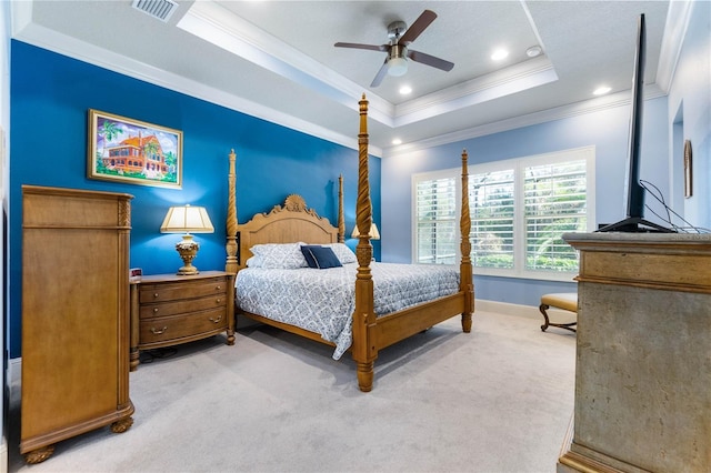 bedroom featuring a raised ceiling, crown molding, light carpet, and ceiling fan