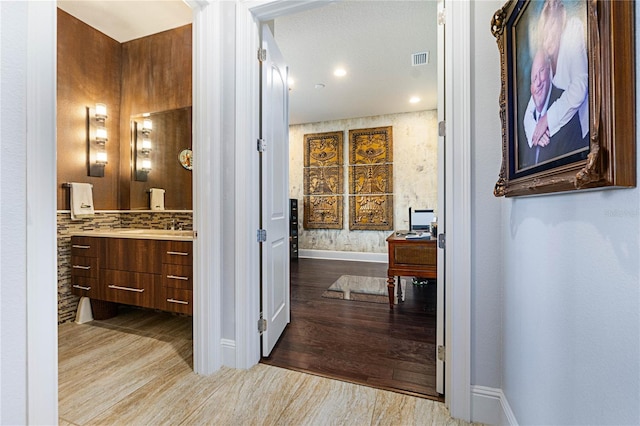 bathroom with vanity, backsplash, and wood-type flooring